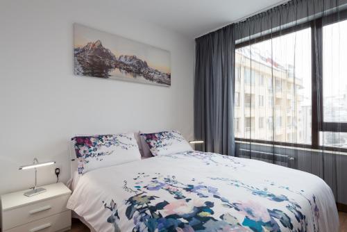 索非亚Grand Vitosha Apartments的一间卧室设有一张床和一个大窗户