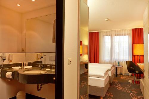 汉诺威汉诺威特里夫酒店的酒店客房设有床、水槽和镜子