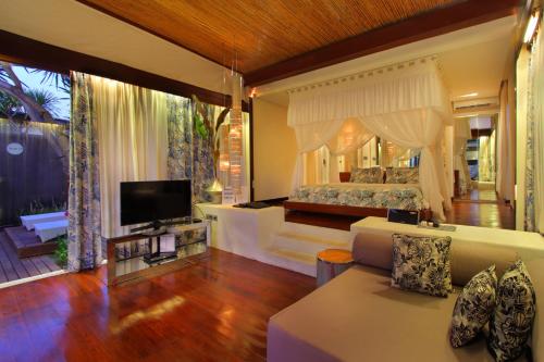 塞米亚克巴厘岛之吻别墅的一间带床和电视的客厅