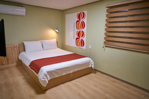 首尔首尔站R旅馆的一间小卧室,配有床和窗户