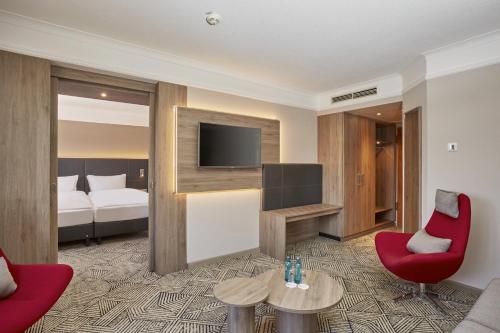 汉诺威汉诺威会展中心H4酒店的酒店客房设有沙发、电视和床。