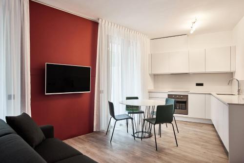科莫拉佩拉拜赛达尔公寓式酒店的厨房以及带桌椅的起居室。