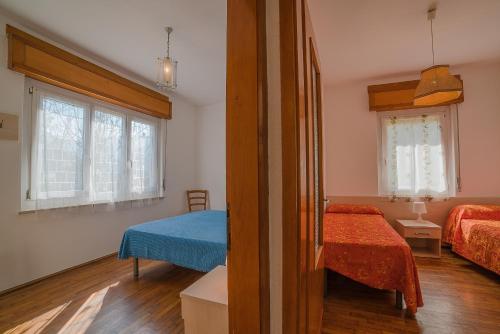 莱德罗Villa Bellavista的带两张床的房间和一间带两个窗户的卧室