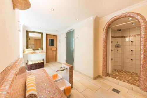 圣安东阿尔贝格科提斯酒店的大型浴室设有浴缸和淋浴。