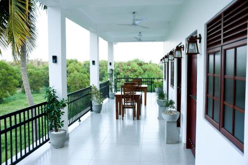 卡图纳耶克Otha Shy Airport Transit Hotel的阳台配有桌椅和植物