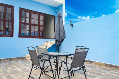 坎佩切Hotel Maculís的庭院配有桌椅和遮阳伞。