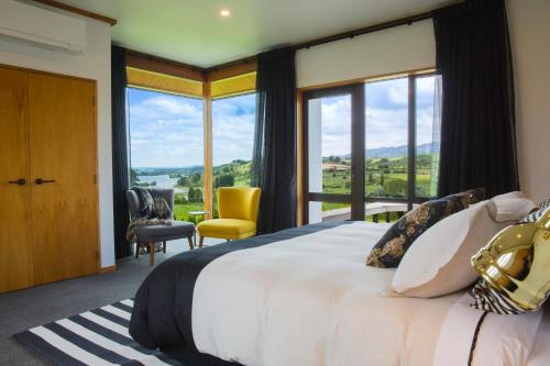 坎布里奇Lakeview Lodge Karapiro的一间卧室设有一张大床和大窗户