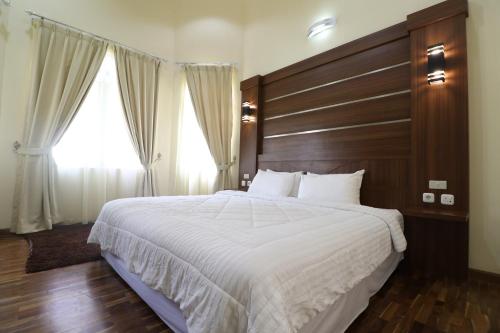 普卡Diyar Villas Puncak NB3/3的一间卧室配有一张大床和木制床头板
