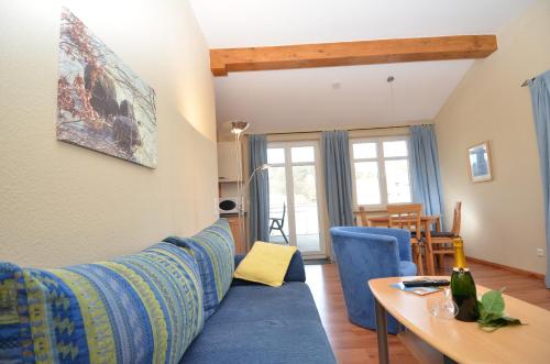 奥斯赛拜-塞林Villa Seerose - Appartement 11的客厅配有蓝色的沙发和桌子