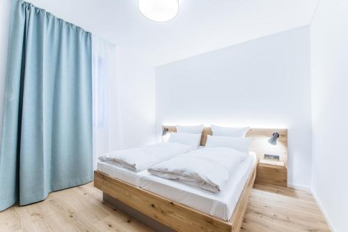 布拉河畔的海登海姆Felsen8的白色卧室配有蓝色窗帘的床