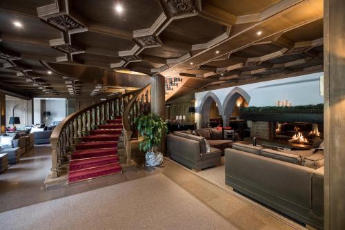 塞尔瓦迪加尔代纳山谷Hotel Aaritz的带沙发的大堂和带壁炉的楼梯