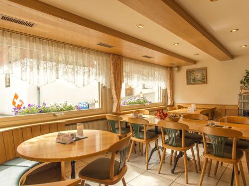 霍斯彭塔尔图尔姆旅舍的餐厅设有木桌、椅子和窗户