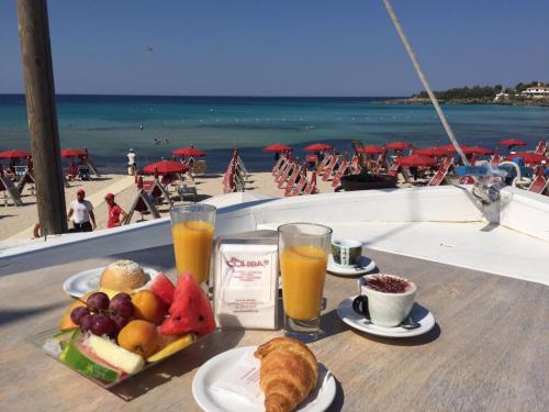 普尔萨诺Le Terrazze B&B的海滩附近的桌子上放着一盘食物和饮料