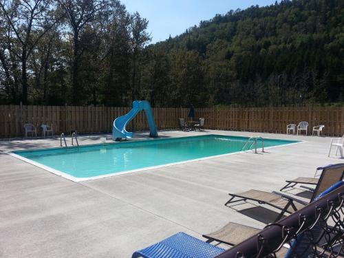 拉马巴耶Motel Le Riviera的庭院中带滑梯的游泳池