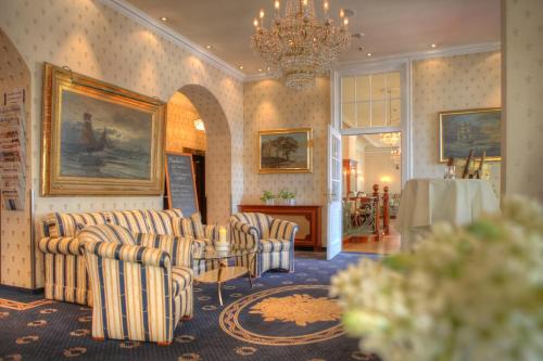 黑灵斯多夫SEETELHOTEL Villa Esplanade mit Aurora的一间带椅子和桌子的房间以及吊灯