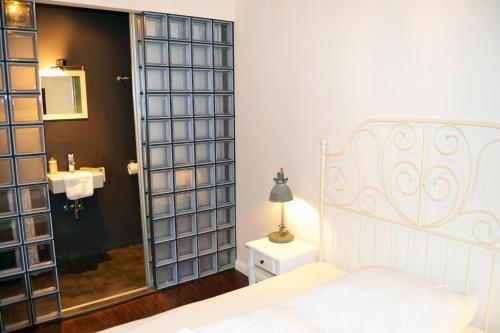 汉堡St. Pauli Lodge的一间带一张床的卧室和一间带镜子的浴室