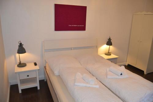 汉堡St. Pauli Lodge的一间卧室配有一张带白色床单和两盏灯的床。