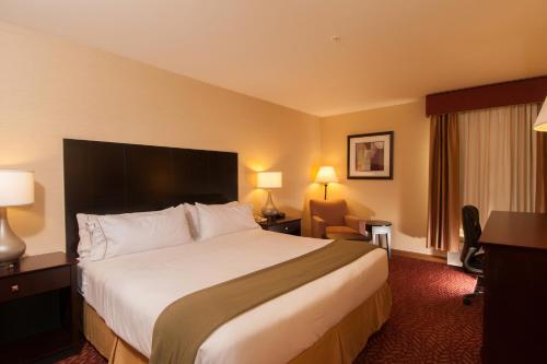 Vernon曼切斯特弗农快捷假日酒店的酒店客房设有一张大床和一张书桌。