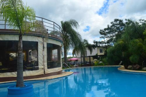 费德拉西翁Paraiso Termal的一座游泳池,旁边是一座棕榈树