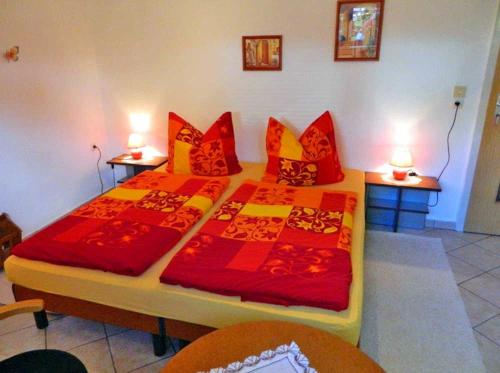 马尔肖Ferienwohnung Malchow SEE 8241的一间卧室配有两张带红色和黄色枕头的床