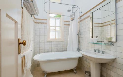 格拉夫顿伊萨卡度假屋的一间带水槽、浴缸和卫生间的浴室