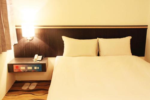 马公丰谷大饭店  的一间卧室配有一张床,桌子上配有一部电话
