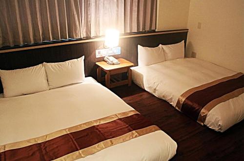 马公丰谷大饭店  的酒店客房设有两张床和一张桌子上的电话