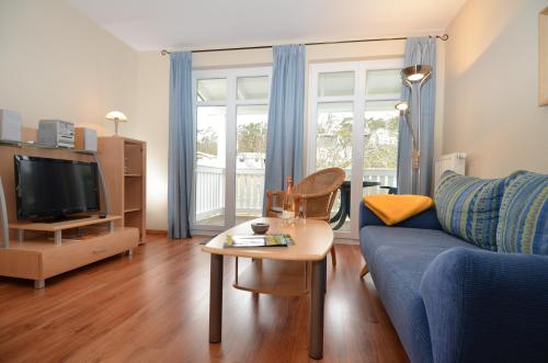 奥斯赛拜-塞林Villa Seerose - Appartement 18的客厅配有蓝色的沙发和桌子