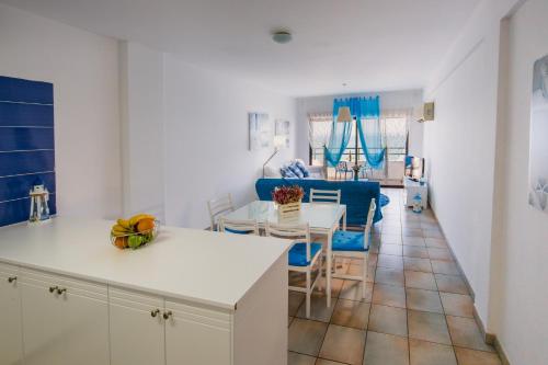 拉纳卡克拉萨斯海滩公寓的厨房以及带桌椅的起居室。