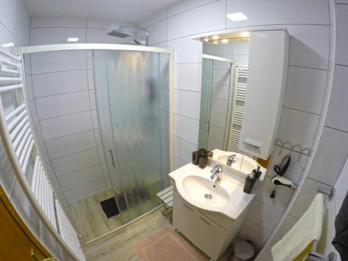 圣马丁娜穆里Apartmani Oletić 4*的白色的浴室设有水槽和淋浴。