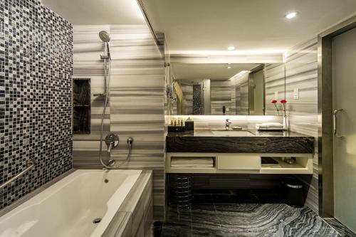 哥打京那巴鲁亚庇凯城酒店的带浴缸、水槽和镜子的浴室