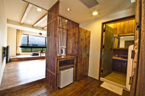 新社劦陶宛陶艺民宿 的一间设有木墙和一扇门及冰箱的客房