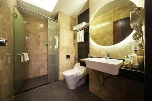 民都鲁民都鲁长廊酒店的一间带水槽、卫生间和镜子的浴室