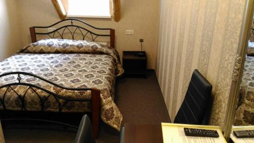 BuožėnaiBuožinta的小房间设有一张床和一张带电脑的书桌