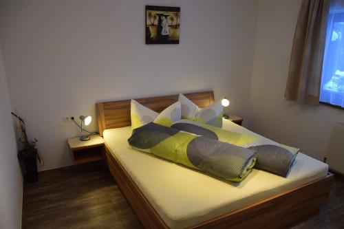 耶岑斯Ferienwohnung Auderer Monika的一间卧室配有带四个枕头的床