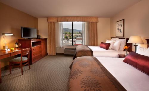 韦纳奇韦纳奇海岸中心酒店的酒店客房设有两张床、一张桌子和一台电视。