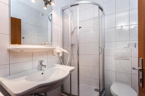 滨湖采尔玛格丽特旅馆的白色的浴室设有水槽和淋浴。
