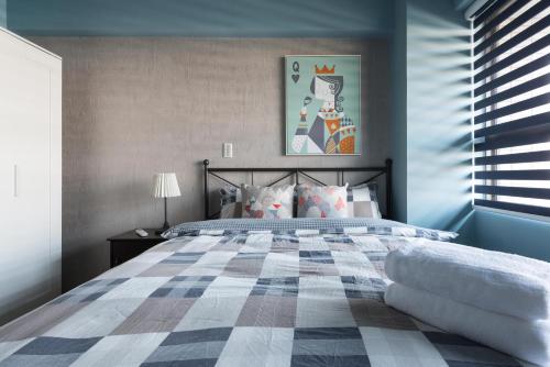 新店LiveGRACE Apartment Xindian的一间卧室配有一张带蓝色墙壁的大床