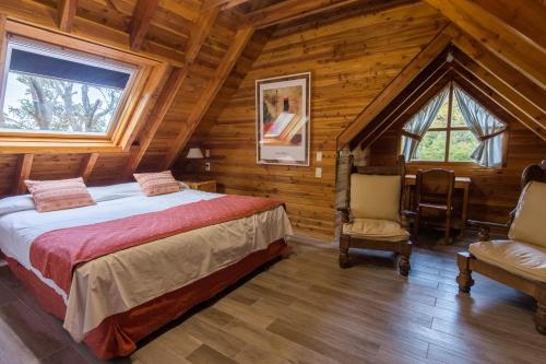 圣卡洛斯-德巴里洛切拉斯玛丽亚德纳韦尔山林小屋的小木屋内一间卧室,配有一张床