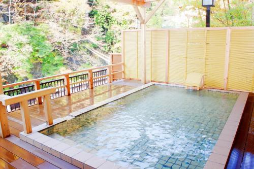 日光一柳阁本馆酒店的一个带长凳的阳台的游泳池