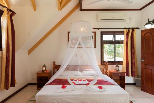 拉迪格岛Chalets d'Anse Reunion的一间卧室配有一张带蚊帐的床