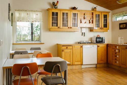 塞尔福斯南中央旅馆 的厨房配有木制橱柜和桌椅