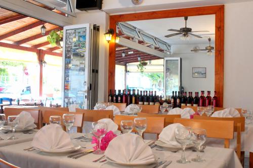 罗德镇罗迪安画廊酒店公寓的用餐室配有白色桌子和葡萄酒瓶