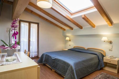 费拉迪普利米罗Hotel Al Prato的一间卧室设有蓝色的床和天窗
