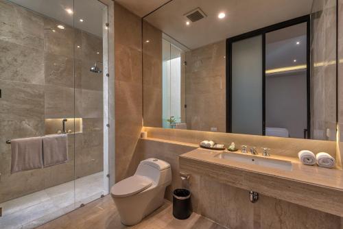 龙目岛库塔可曼格住宿加早餐旅馆 的浴室配有卫生间、盥洗盆和淋浴。