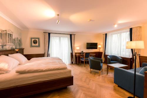 慕尼黑Hotel & Gaststätte zum Erdinger Weißbräu的配有一张床和一张书桌的酒店客房