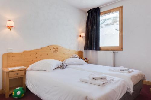 里蒙纽耶夏雷阿多尼斯酒店的卧室设有一张白色大床和一扇窗户。