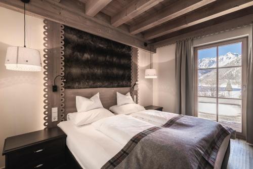 MadonnaHotel & Chalets Edelweiss的一间卧室设有一张大床和一个窗户。