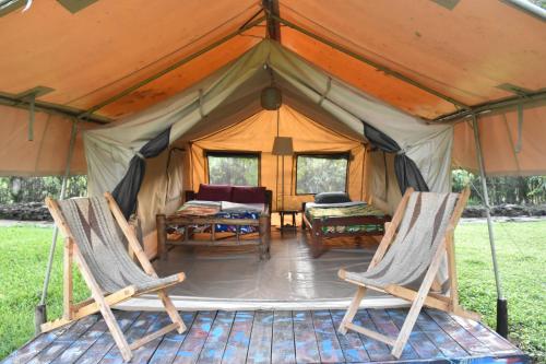 NyakinamaRed Rocks Rwanda - Campsite & Guesthouse的帐篷配有两把椅子和一张桌子