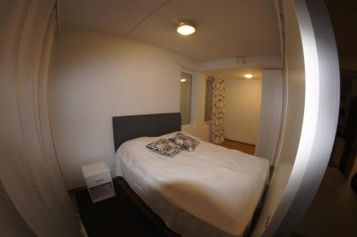 托尔尼奥Sarastus的一间小卧室,配有白色的床和镜子